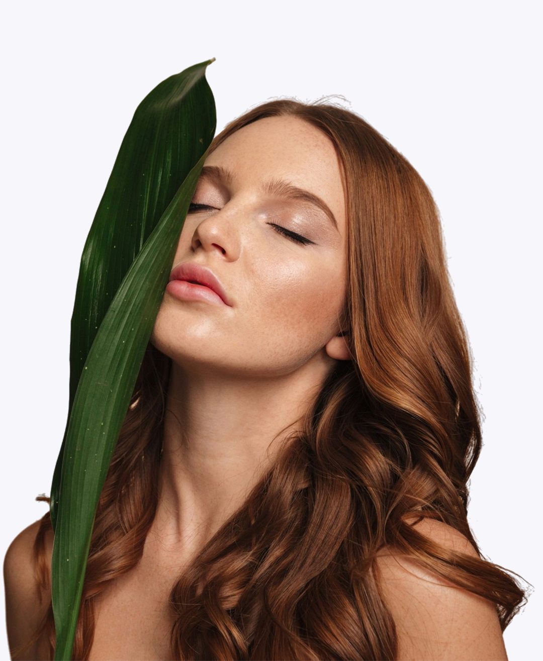 Femme aux cheveux roux tenant une feuille verte